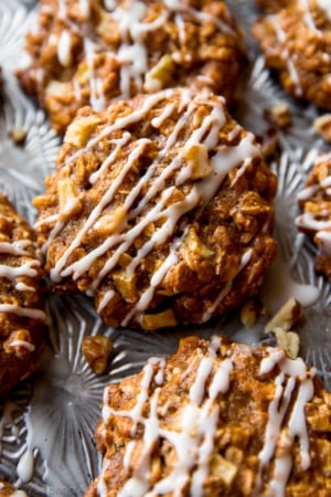 apple cinnamon oatmeal cookies with maple icing on a baking sheet