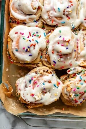 birthday cake funfetti cinnamon rolls in lined glass pan.