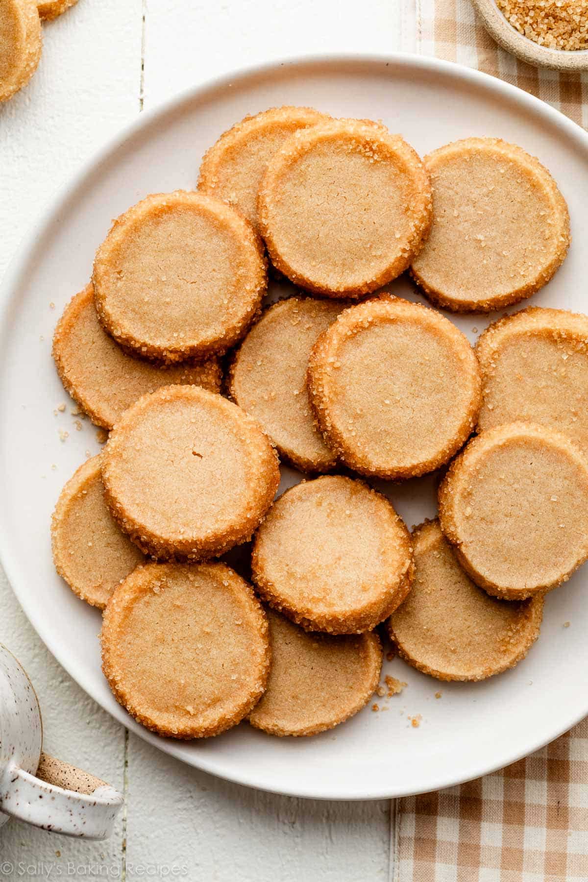 brown sugar shortbread on white plate with light brown gingham linen.