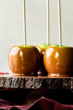 caramel apples on a wood slice cake stand