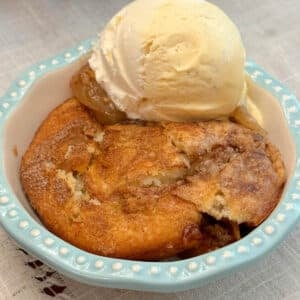 apple cobbler with ice cream in blue bowl.