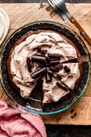 sliced chocolate pudding pie in Oreo cookie crust with mocha whipped cream on top.