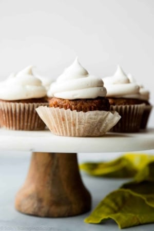 carrot cake cupcakes on a marble and wood cake stand