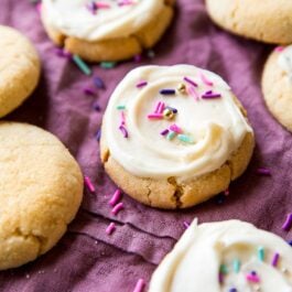 cream cheese sugar cookies topped with cream cheese frosting and sprinkles