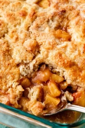 close-up of juicy peach cobbler with biscuit topping.