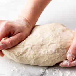 floured hands kneading dough.