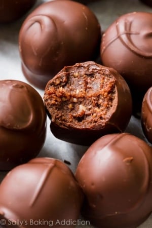 dark chocolate almond truffles with a bite taken from one showing the filling