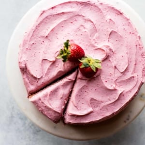 overhead image of homemade strawberry cake on a marble cake stand