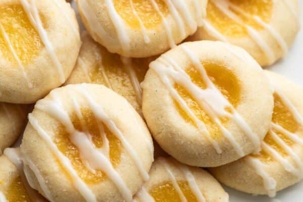 close-up photo of lemon thumbprints with icing on white plate.