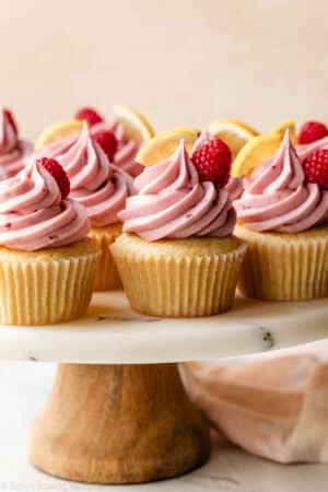 lemon raspberry cupcakes on marble cake stand.