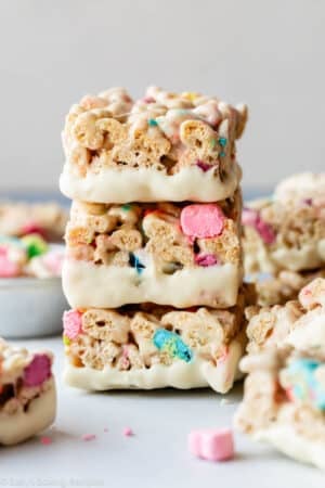 stack of 3 white chocolate dipped Lucky Charms cereal treats.