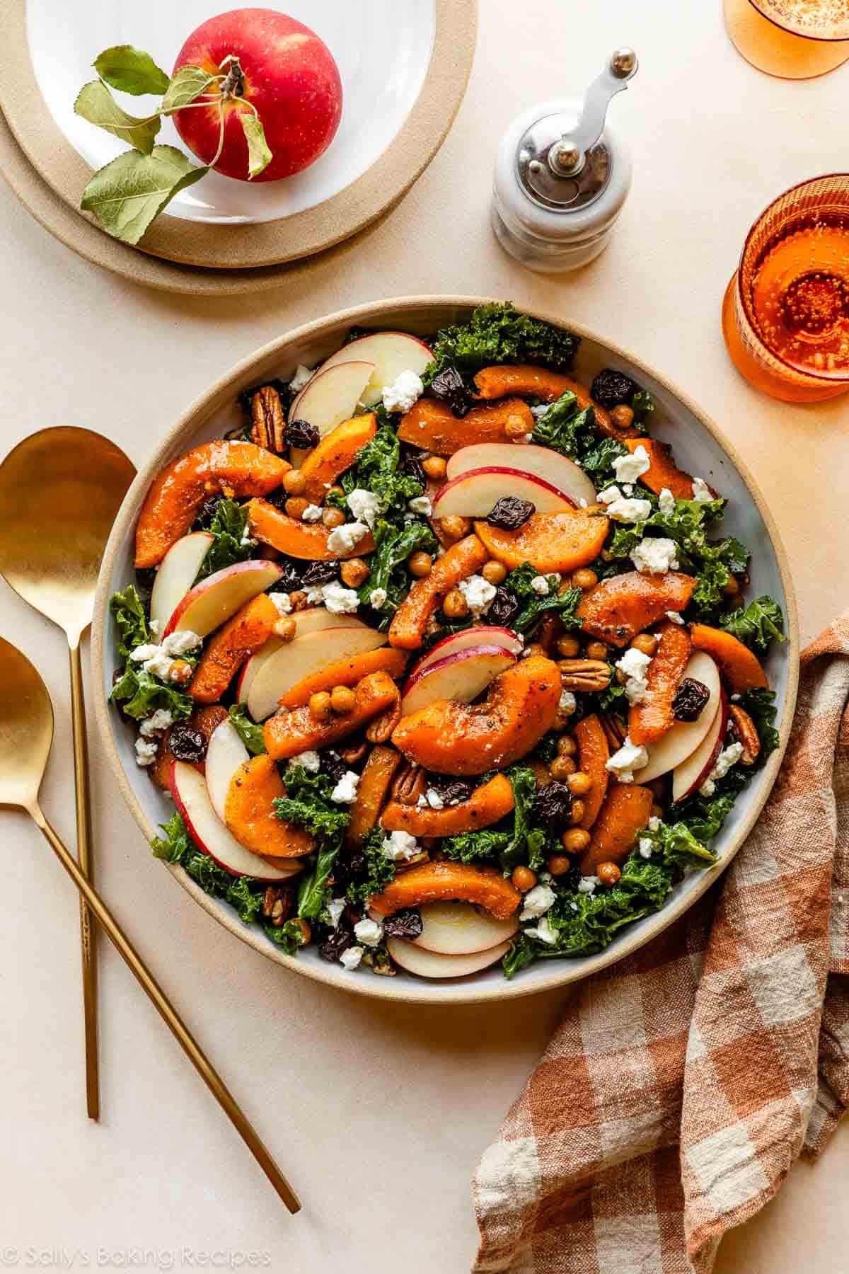 butternut squash and kale salad in bowl with apples, dried cherries, goat cheese, and pecans.