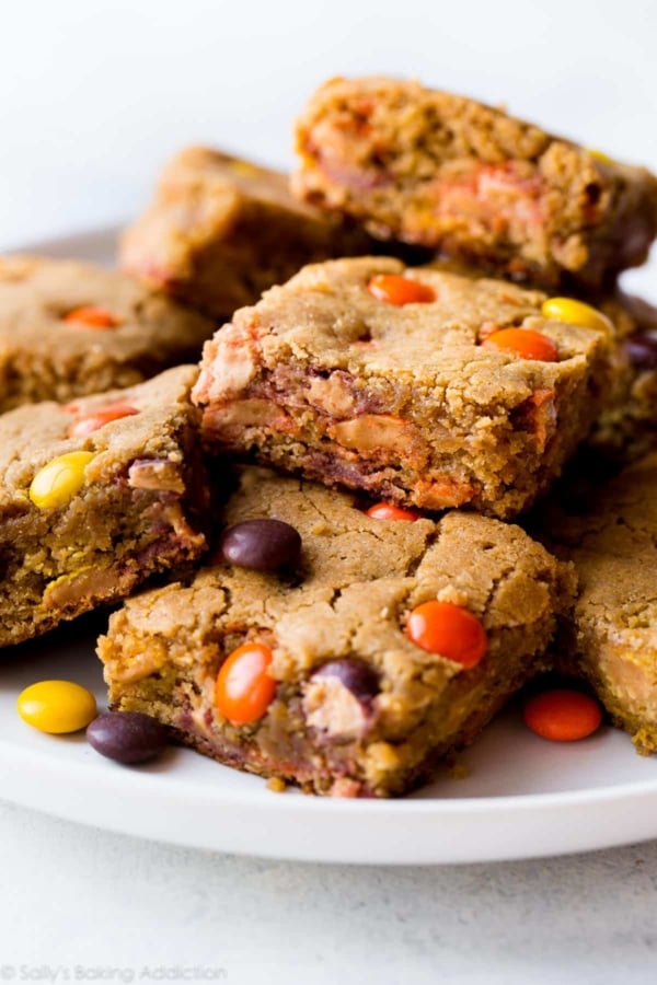 peanut butter blondies stacked on a white plate