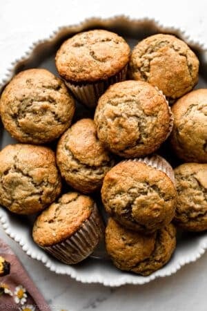 banana muffins piled together in white baking dish.