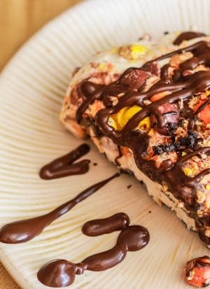 slice of skinny peanut butter pie with chocolate sauce on a cream plate