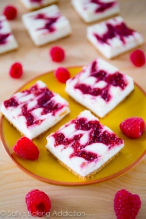 raspberry cheesecake bars on a yellow plate