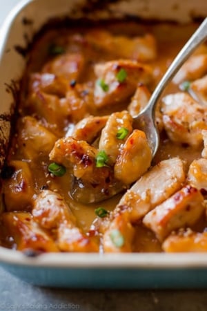 sweet chili chicken in a baking dish with a serving spoon