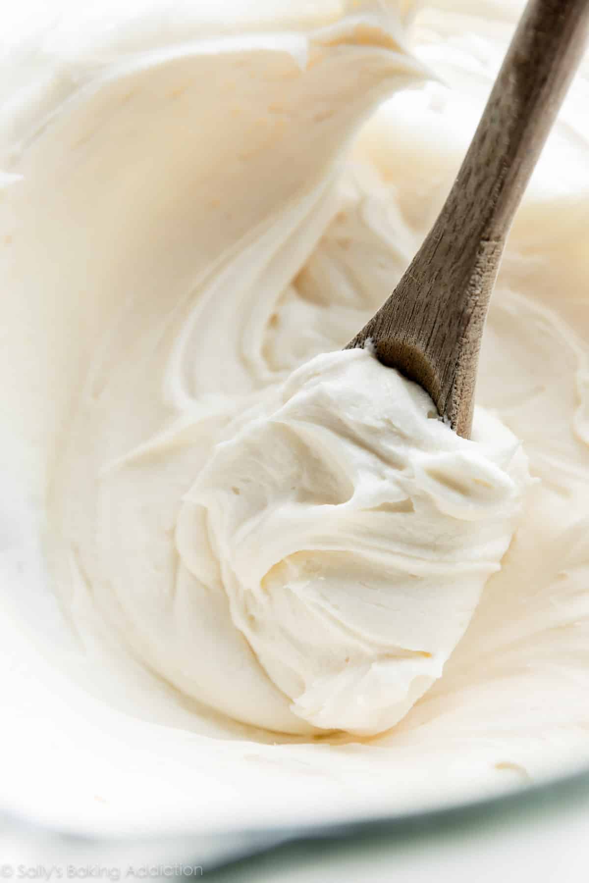 vanilla buttercream in a glass bowl with wooden spoon